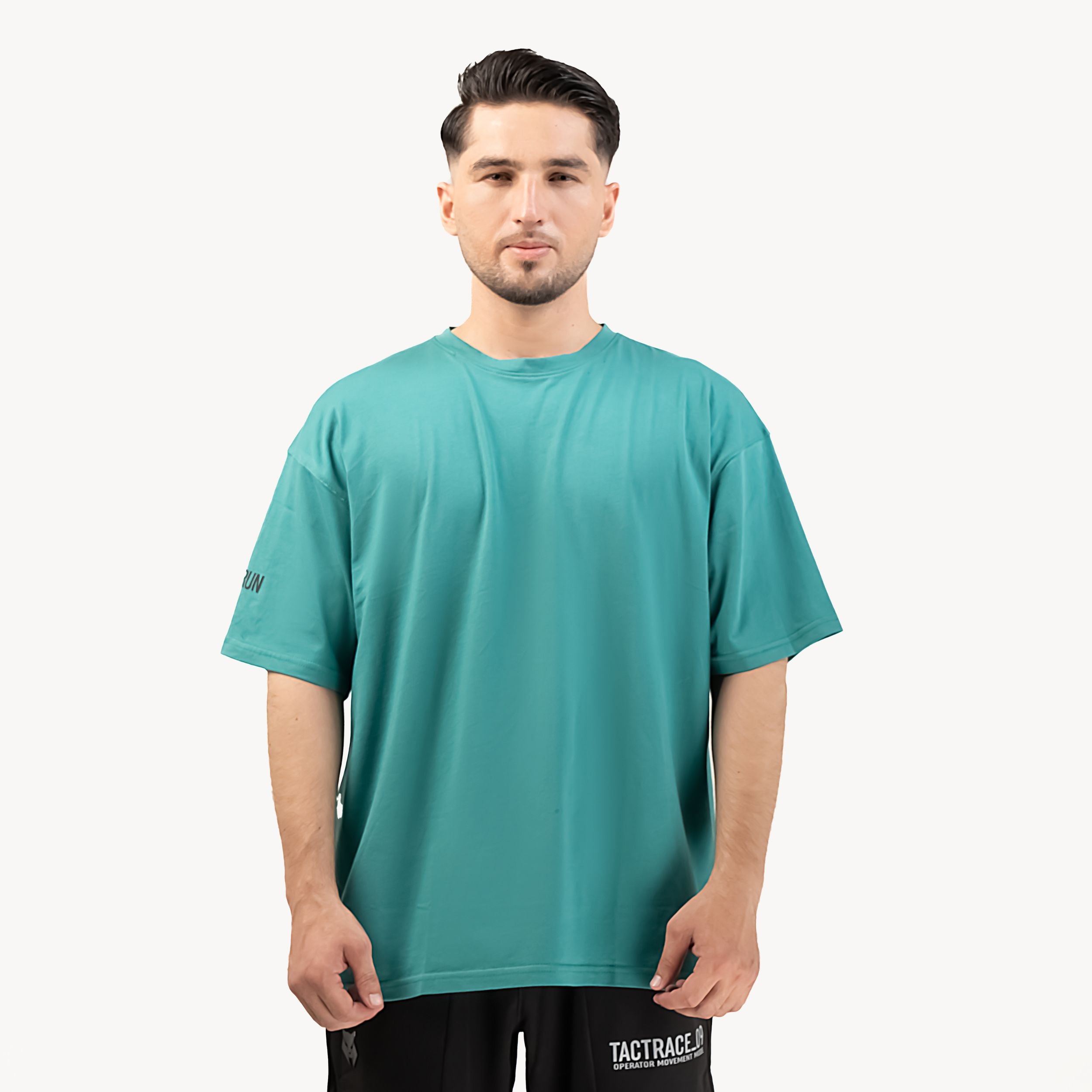 OPERATOR_77 OVERSIZED TEE — ROUGE GREEN — Front-facing upper body on male model, teal tee clean oversized silhouette with su