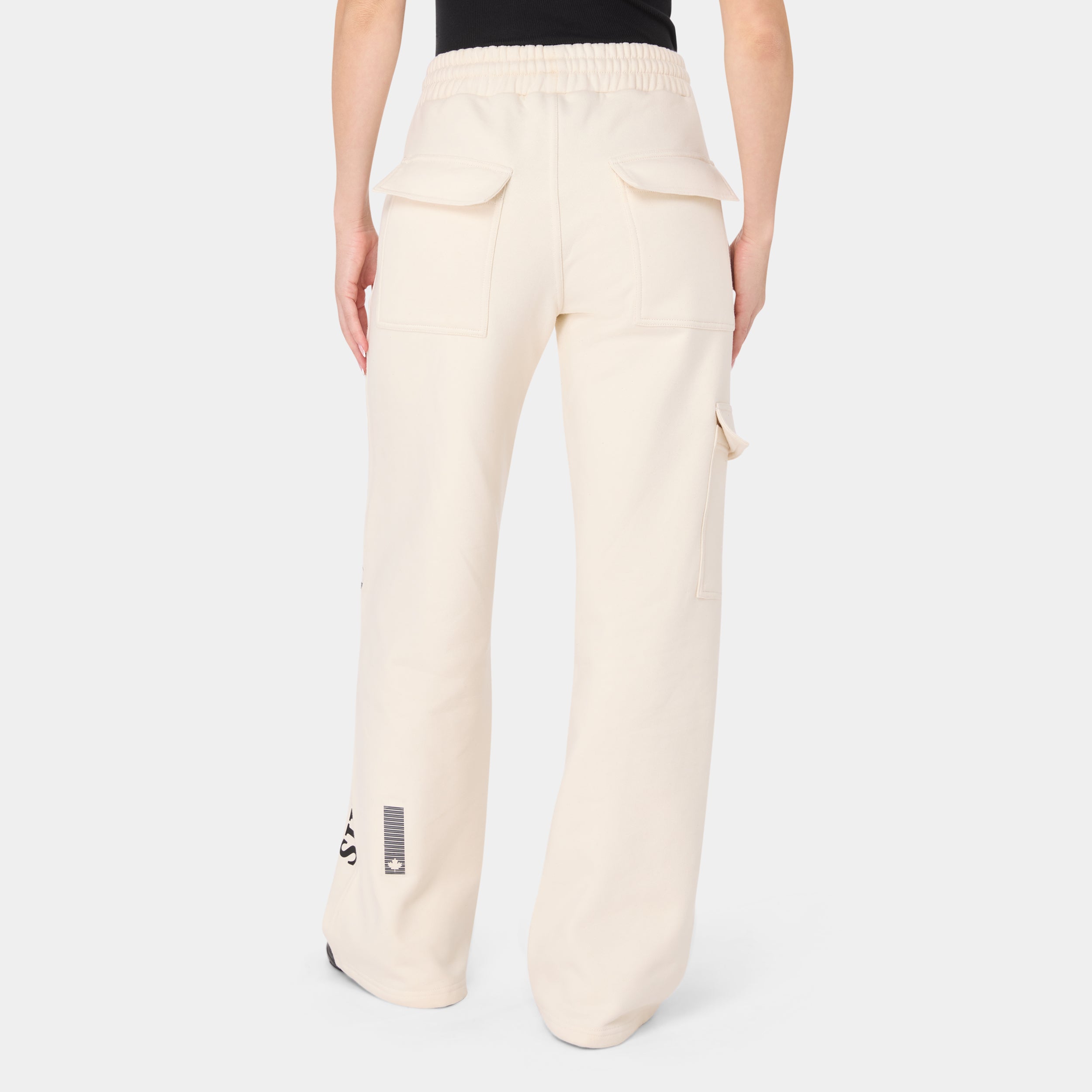 ALPHAFIRE BOTTOM — TACTICAL BEIGE — Back view waist-down on model, cream cargo pants with dual rear flap pockets and barcode