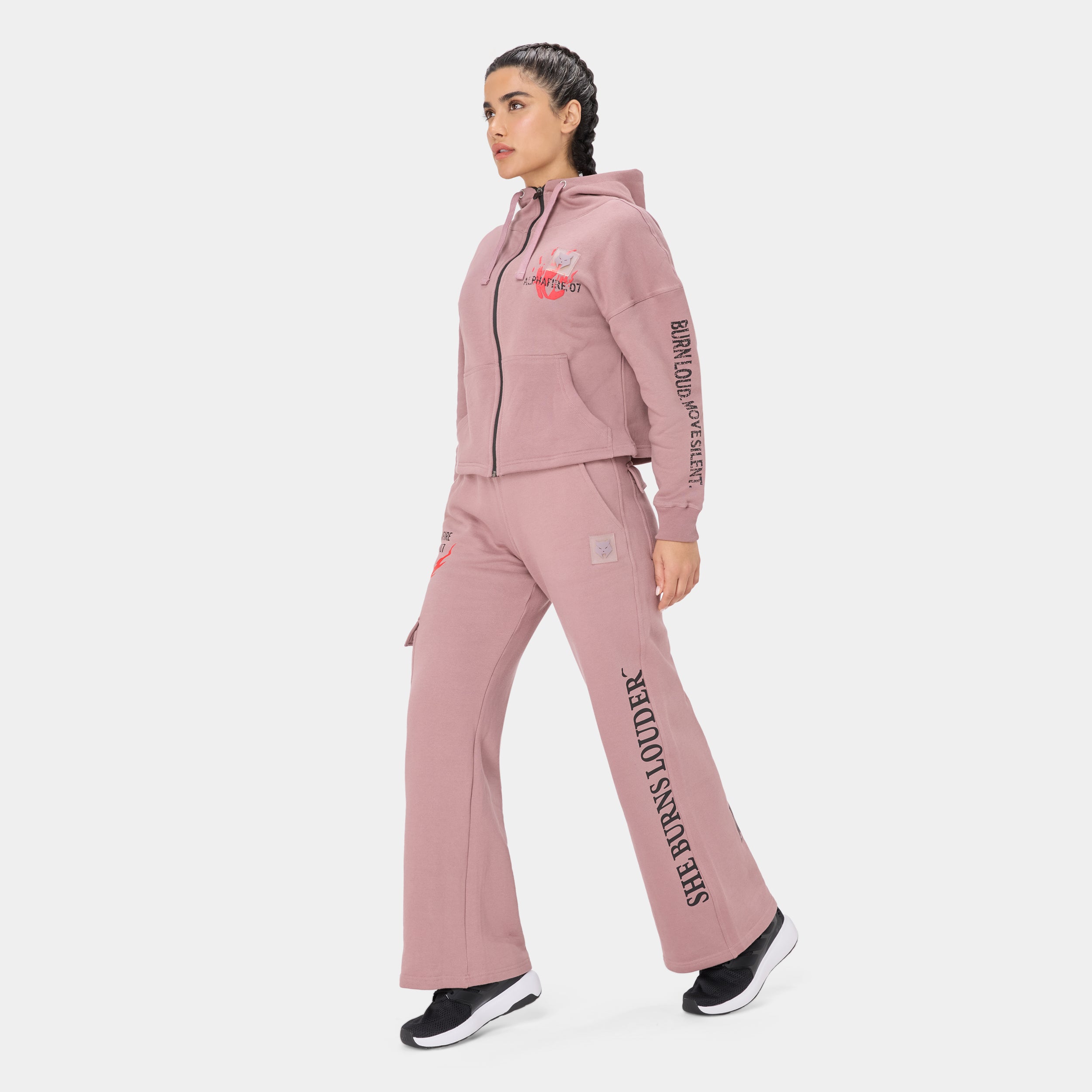 ALPHAFIRE CROP HOODIE — STORM ROSE — Side walking view full-body, dusty pink tracksuit with SHE BURNS LOUDER leg text and