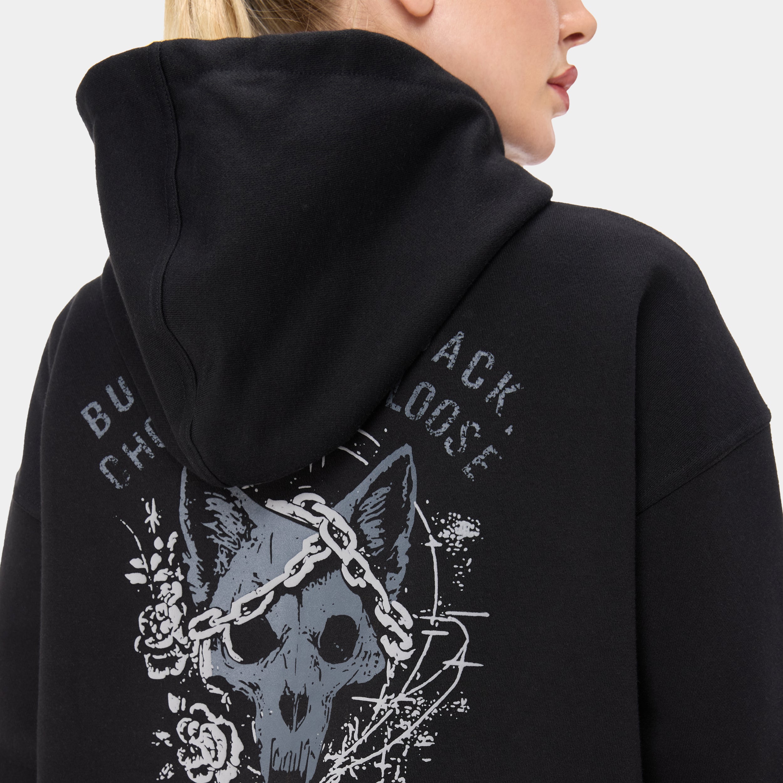 LOCKFEM_05 HOODIE — WAR BLACK — Close-up back/shoulder detail, black hoodie zoomed-in wolf skull graphic with chains and ros
