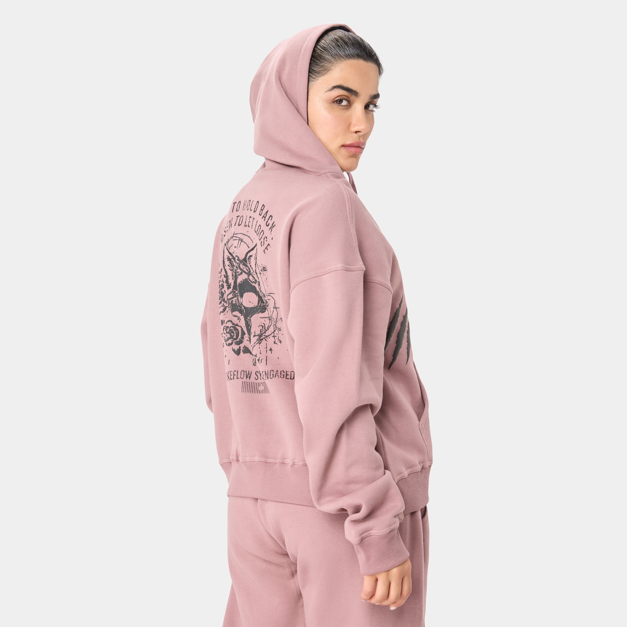 LOCKFEM_05 HOODIE — STORM ROSE — Back/side view upper body, dusty pink hoodie with wolf skull/butterfly back graphic and Bui