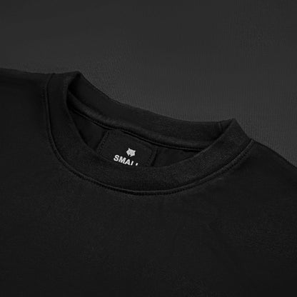 OPERATOR_77 OVERSIZED TEE — WAR BLACK — Flat-lay close-up, black tee inner neck label showing wolf logo and size tag