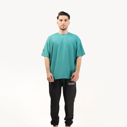 OPERATOR_77 OVERSIZED TEE — ROUGE GREEN — Full-body straight-on view on male model, white background, teal tee complete outf