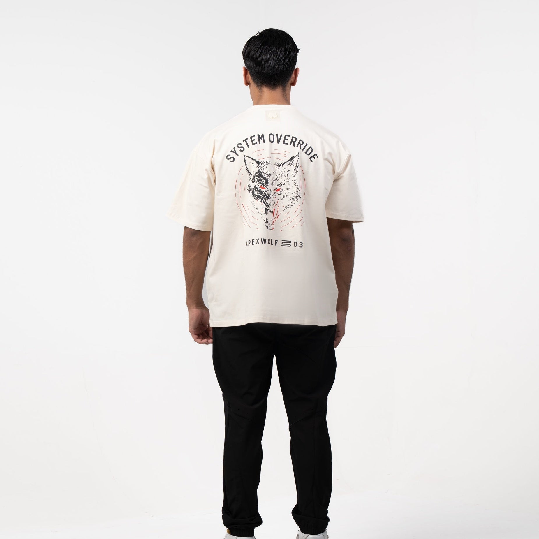 Person wearing a white t-shirt with graphics on the back, standing against a white background