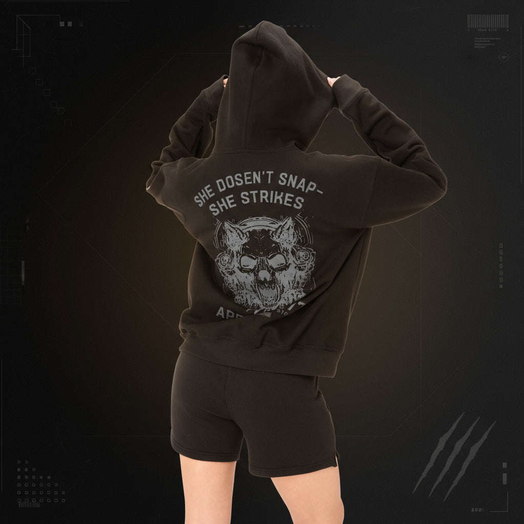 Black hoodie with graphic design and text on the back, worn by a person against a white background